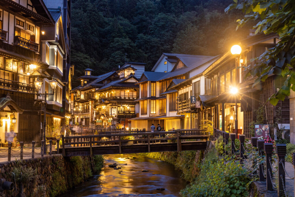 銀山温泉の夜景。ガス灯が灯る幻想的な温泉街と川沿いに並ぶ大正時代の木造旅館